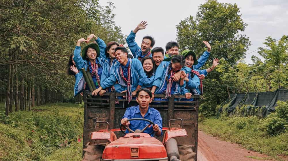 Internationales Team Von Freiwilligen Helfern Auf Einem Traktor In Südostasien als Freiwilligenarbeit im Ausland