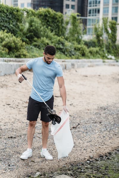 Ein Mann sammelt Müll am Flussufer